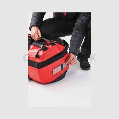 Bolsa de viaje Atlantis de Stormtech de 89L con correas de mochila, en rojo, vista de detalle etiqueta